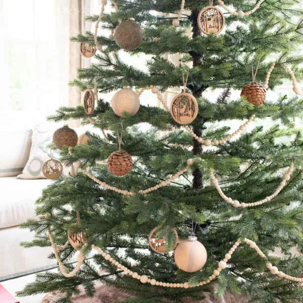 Rustic Reindeer ornament alongside wooden decorative garland and pine cones on fir artificial Christmas tree