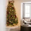 BerryandPinePicks12Pack3 Lit Christmas tree topped with Berry and Pine Picks in a cozy living room setting.