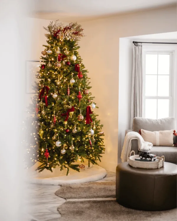 BerryandPinePicks12Pack3 Lit Christmas tree topped with Berry and Pine Picks in a cozy living room setting.