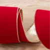 Close-up of coiled Classic Red Ribbon with metallic gold wired edging on a light wooden background.