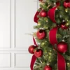 Classic Red Ribbon with gold edging draped through a Christmas tree paired with matching red bauble ornaments.