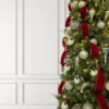Close-up of Classic Red Ribbon woven through tree branches styled alongside gold and champagne ornaments.
