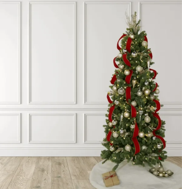 Full-length shot of a Christmas tree decorated with Classic Red Ribbon and metallic gold ornaments standing on a white tree skirt.
