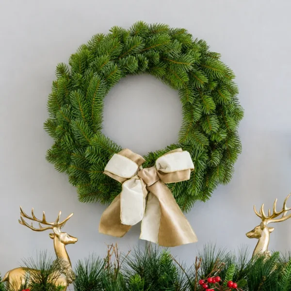 KingDouglasFirWreathUnlit King Douglas Fir Wreath adorned with a gold and white ribbon bow hanging above a mantel flanked by gold reindeer.