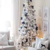 King Flock Slim Artificial Christmas Tree decorated with black bows, silver ribbons, and white ornaments in a cozy living room.