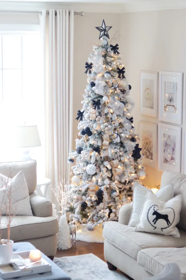 King Flock Slim Artificial Christmas Tree decorated with black bows, silver ribbons, and white ornaments in a cozy living room.