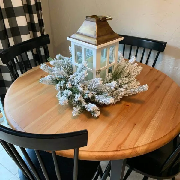 KingFlockWreath3 King Flock Wreath styled flat as a table centerpiece wrapped around a white lantern on a round wooden dining table.
