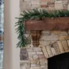 KingNobleGarland King Noble Fir Garland featuring realistic noble fir foliage cascading down a dark wood beam on a stone fireplace.
