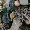 Silver Netted Stretch Ribbon woven through Christmas tree branches alongside gold ornaments and metallic sprays.