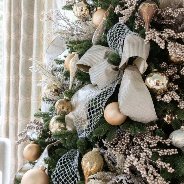 Silver Netted Stretch Ribbon layered behind a champagne bow on a decorated Christmas tree.