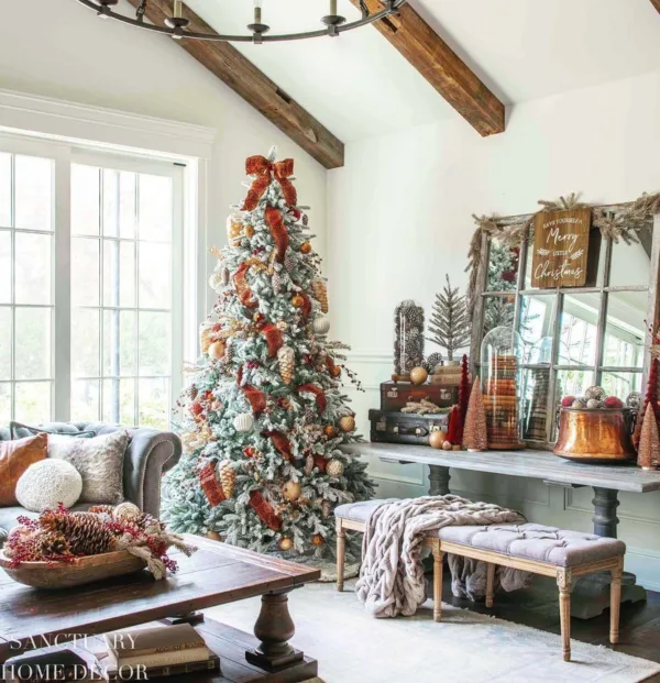Queen Flock Full Artificial Christmas Tree styled with rust-colored velvet ribbon and metallic ornaments in a rustic living room.