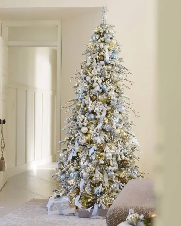 Queen Flock Slim Artificial Christmas Tree decorated with ice blue ribbon and silver ornaments in a hallway.