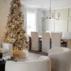 Queen Flock Slim Artificial Christmas Tree lavishly decorated with gold ribbons and champagne ornaments in an open dining room.