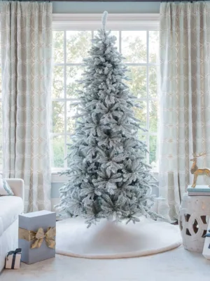 Unlit Queen Flock Slim Artificial Christmas Tree displayed in a sunlit room in front of a window.