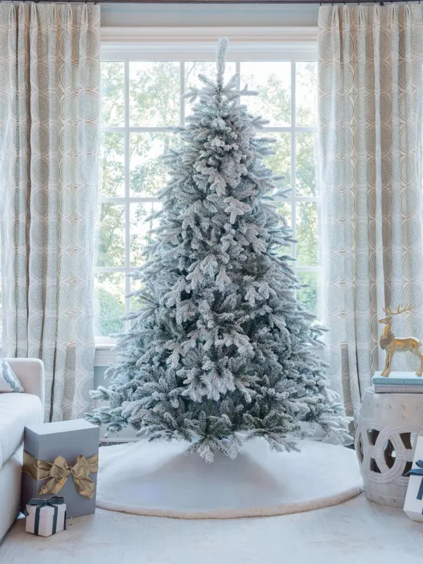 Unlit Queen Flock Full Artificial Christmas Tree featuring heavily frosted branches on a white tree skirt.