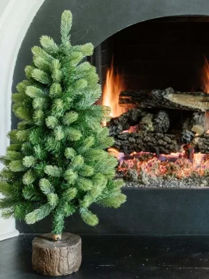 3' Royal Fir Artificial Christmas Tabletop Tree with realistic green needles in a faux wood log stand by a white fireplace hearth.