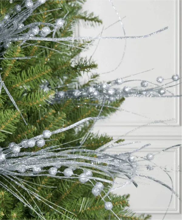 Close-up of glittery Silver Burst Picks with beaded spray branches tucked into evergreen pine branches.