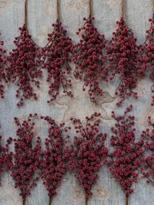 Sugar Berry Picks2 Multiple red frosted Sugar Berry Picks arranged on a light-colored carpet.