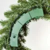 Close-up of the green battery compartment and timer control switch on the back frame of a Cypress Spruce Wreath.