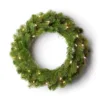 Pre-lit King Douglas Fir Wreath with lush green foliage glowing with warm clear lights on a white background.