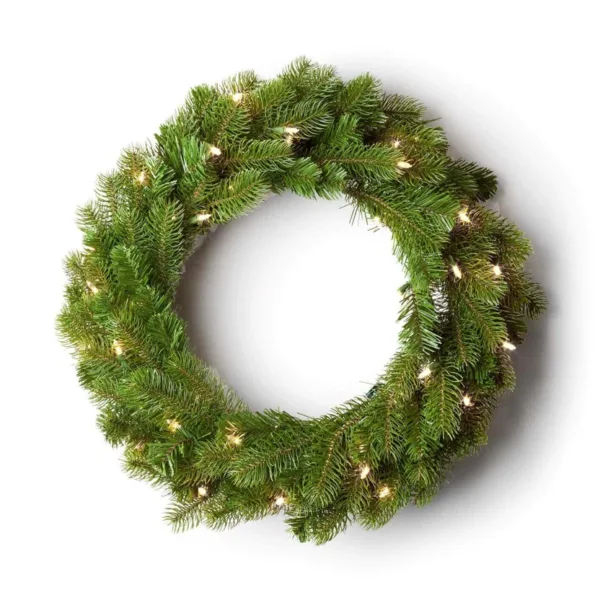 Pre-lit King Douglas Fir Wreath with lush green foliage glowing with warm clear lights on a white background.