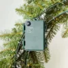 Close-up of the green battery pack and timer control box attached to the back frame of a King Douglas Fir Wreath.