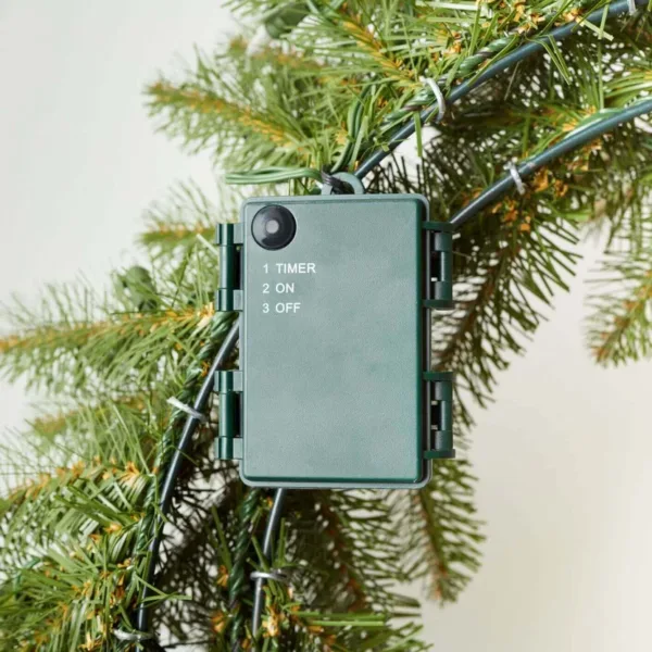 Close-up of the green battery pack and timer control box attached to the back frame of a King Douglas Fir Wreath.