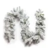 King Flock Garland laid flat in a curved wave pattern with heavy snow flocking on a plain white background.