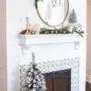 3' King Flock Artificial Christmas Tabletop Tree in a metal pot placed on a patterned hearth below a shiplap mantel.
