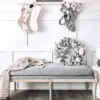 king-flock-wreath-1 King Flock Wreath resting on an upholstered entryway bench below hanging Christmas stockings.