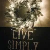 kingflockLitwreath Pre-lit King Flock Wreath glowing directly above a rustic dark wood decorative wall sign.