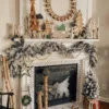 King Flock Garland draped across a white fireplace mantel decorated with wooden trees, beads, and rustic bells.