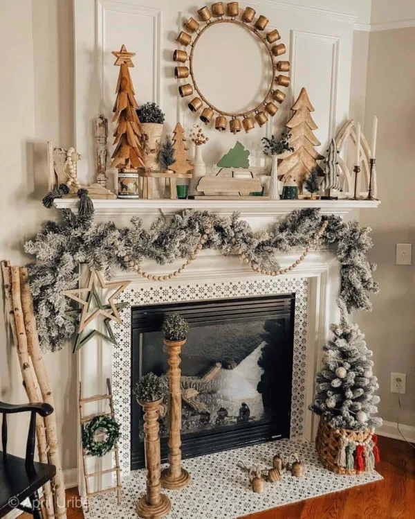 King Flock Garland draped across a white fireplace mantel decorated with wooden trees, beads, and rustic bells.