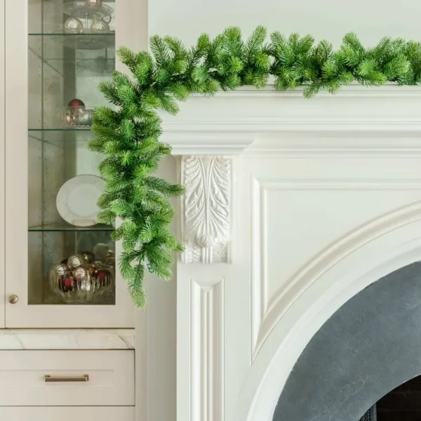 Royal Fir Garland with dense green pine foliage cascading over the corner of a white fireplace mantel next to glass cabinets.
